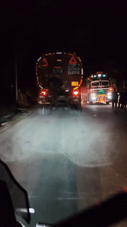 Night road travel near Vashisht, navigating trucks and mist