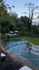 Two swimmers enjoy infinity pool at Nusa Penida resort