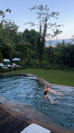 Two swimmers enjoy infinity pool at Nusa Penida resort