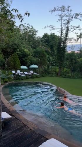 Two swimmers enjoy infinity pool at Nusa Penida resort