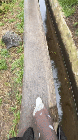 Two walkers navigate foggy mountain canal path in Portugal