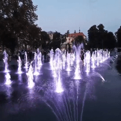 Purple-lit fountain glows in a Lviv square at dusk