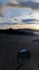 Sunset documented over Juan Griego coastal road and colonial buildings