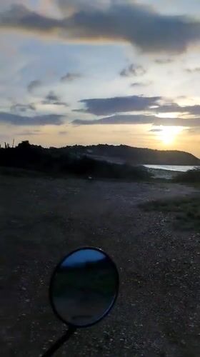 Sunset documented over Juan Griego coastal road and colonial buildings