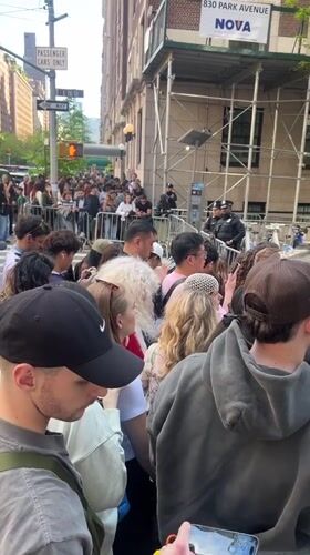 Crowd gathers behind barriers as celebrity escorted in NYC