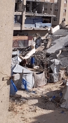 Temporary camp with tents observed amid debris field