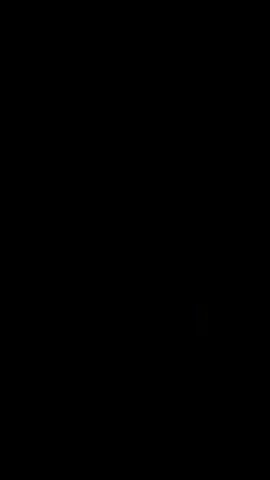 The video shows a dark scene with a lit window in the lower right corner. The window appears to have several panes and is illuminated from within, suggesting there is a light source or activity inside. The rest of the frame is black, indicating darkness or a lack of visible detail. There are no people or discernible objects visible outside of the lit window.