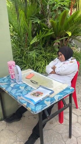 Security guard rests in Kuala Lumpur park setting