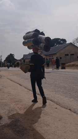 Pedestrians walk streets in Kaduna during afternoon hours