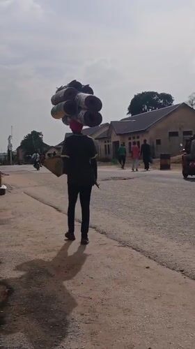 Pedestrians walk streets in Kaduna during afternoon hours