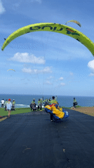 Paragliders launch from clifftop site in Kuta Selatan
