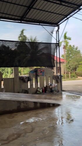 Man opens SUV hood at Indonesian car wash facility