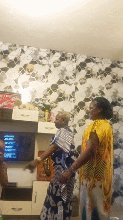 Family gathering features dancing and dining in living room