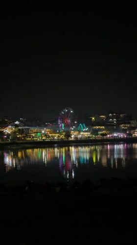 Nighttime scenes in Pokhara feature lit Ferris wheel, street dancing