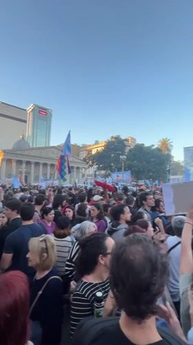 Crowd gathers with signs, flags in Buenos Aires square