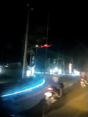 Evening traffic flows through illuminated Banda Aceh street
