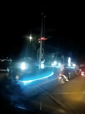 Evening traffic flows through illuminated Banda Aceh street