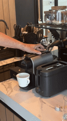 Person photographs Nespresso machine operation in Kuta Selatan
