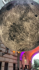 Inflatable moon installation at Budapest riverfront sunset event