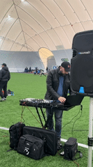 DJ provides music at children's indoor soccer session