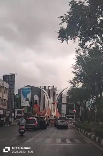Morning traffic flows through rainy Banda Aceh intersection
