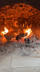 Wood fire burns in brick oven in Polski Trambesh