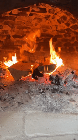 Wood fire burns in brick oven in Polski Trambesh
