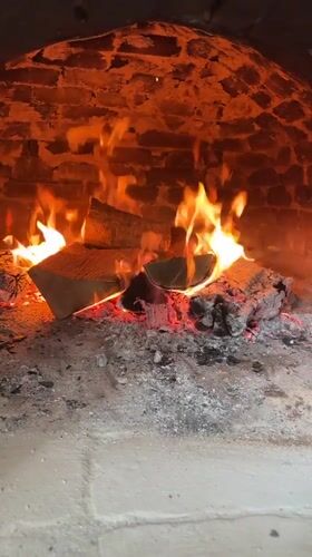 Wood fire burns in brick oven in Polski Trambesh
