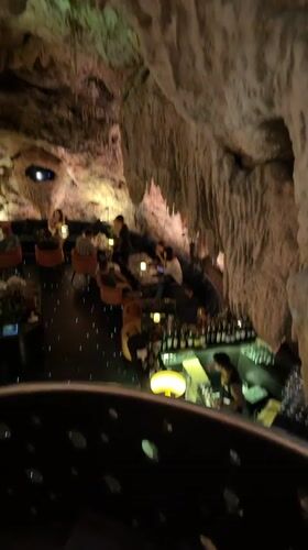 Inside Bali's cave restaurant with dramatic lighting and ceiling projections