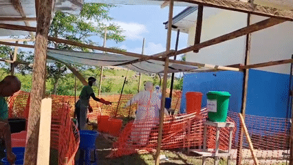 Health workers run outdoor decontamination stations in Tchere, DRC