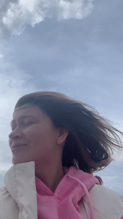 Woman enjoys windy day by water in Chaikovsky