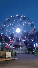 Yekaterinburg amusement park glows at dusk with festoon and Ferris wheel lights