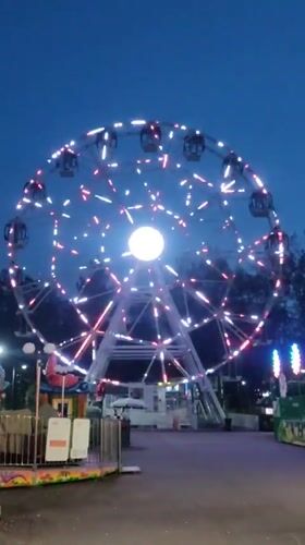 Yekaterinburg amusement park glows at dusk with festoon and Ferris wheel lights