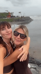 Two women take selfies with pug in Bali beach area