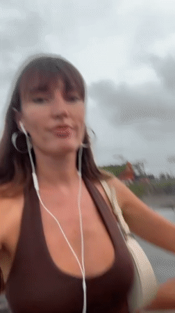 Two women take selfies with pug in Bali beach area