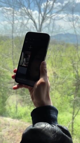 Person photographs railroad tracks with smartphone in Anevo, Bulgaria