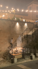 Evening diners gather at illuminated Tel Aviv outdoor restaurant
