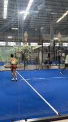 Indoor padel match on a blue court in northern Thailand