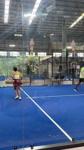 Indoor padel match on a blue court in northern Thailand