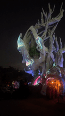 Illuminated face sculpture glows with shifting color in Kediri night