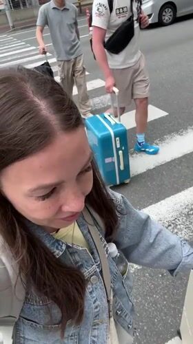 Early morning travelers with luggage spotted near Fukuoka hotel