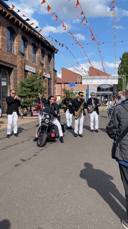 Street band performs with motorcycle-seated singer in Saarbrücken