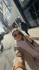 Woman documents sunny afternoon with selfies on Berlin street