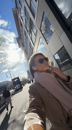 Woman documents sunny afternoon with selfies on Berlin street