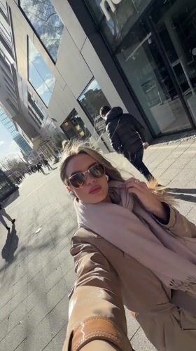 Woman documents sunny afternoon with selfies on Berlin street