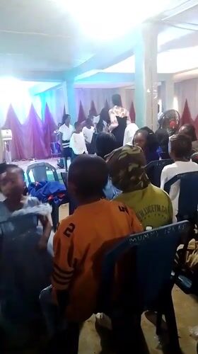 Blue-robed ceremony unfolds inside and outside a community hall