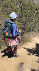Hiker checks phone on mountain trail in Nepal