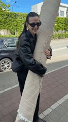 Woman carries rug through Belgian suburb streets