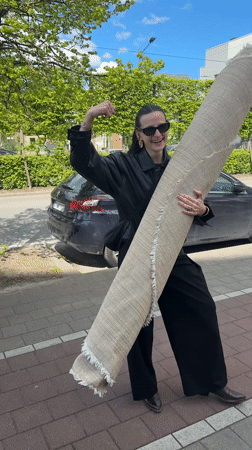 Woman carries rug through Belgian suburb streets