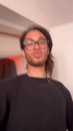 Person filmed making camera gestures in Paris workspace